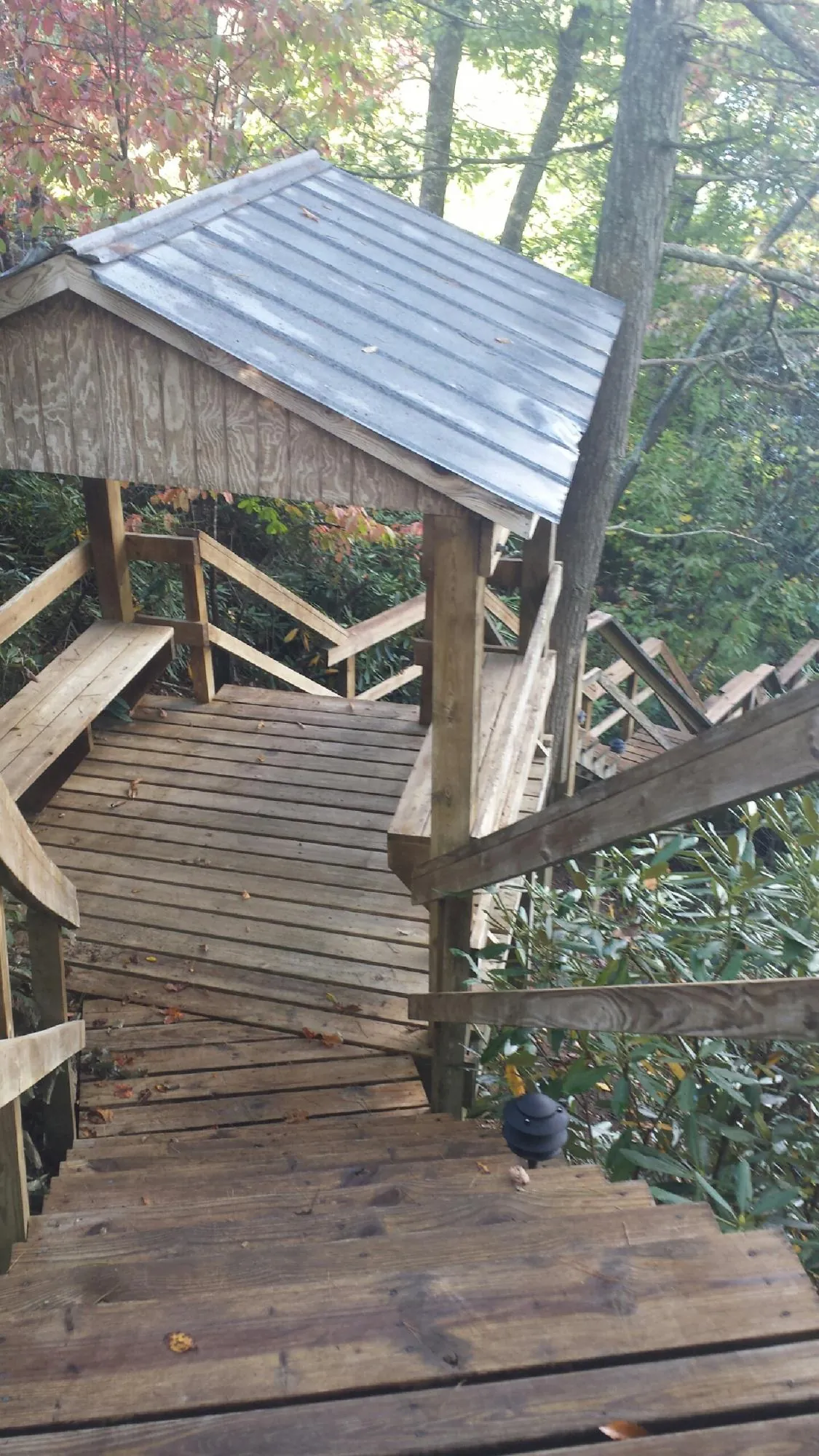 Metal roofed shelter over wooden steps on a wooded walkway — Skylight Repair & Installation work by our crew in Block Island
