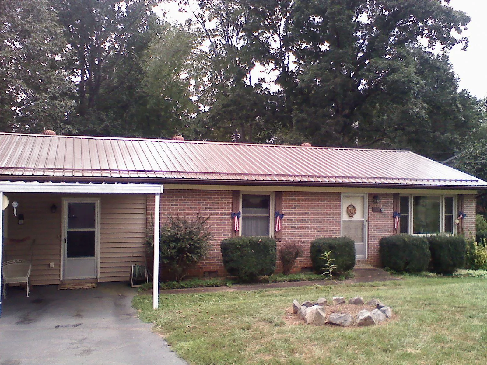 Bronze metal roof and carport on a brick ranch home — Roof Repair work by our crew in Block Island